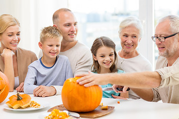 Image showing happy family sitting with pumpkins at home