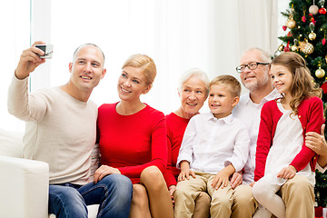 Image showing smiling family with camera at home