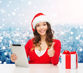 Image showing smiling woman in santa hat with gift and tablet pc