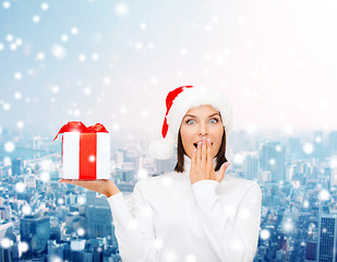 Image showing smiling woman in santa helper hat with gift box