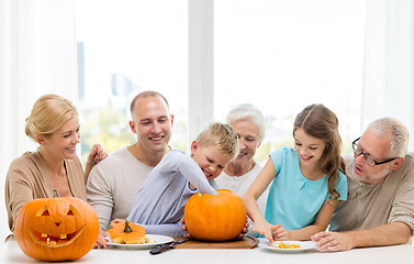 Image showing happy family sitting with pumpkins at home