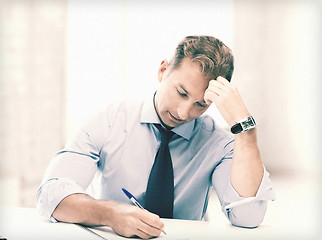 Image showing businessman writing in notebook