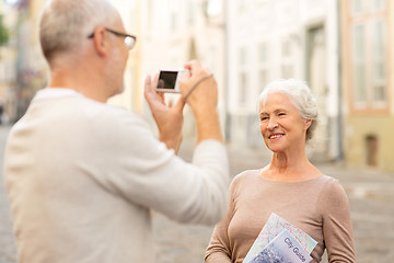 Image showing senior couple photographing on city street