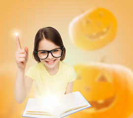 Image showing smiling girl in glasses over pumpkins background