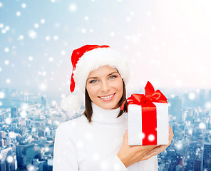 Image showing smiling woman in santa helper hat with gift box