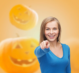 Image showing smiling young woman pointing finger at you