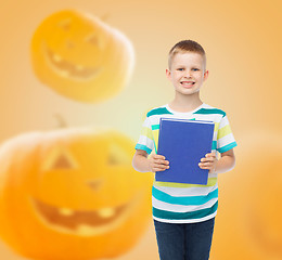 Image showing smiling little student boy with blue book