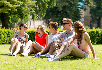 Image showing group of smiling friends outdoors sitting on grass