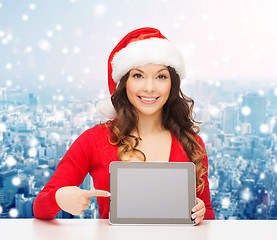 Image showing smiling woman in santa hat with gift and tablet pc