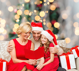 Image showing happy family in santa helper hats with gift boxes