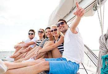 Image showing smiling friends sitting on yacht deck