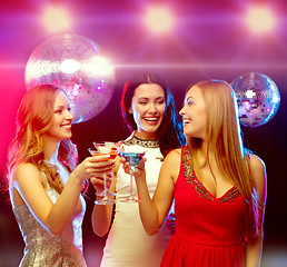 Image showing three smiling women with cocktails and disco ball