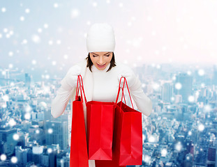 Image showing smiling young woman with red shopping bags