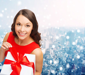 Image showing smiling woman in red dress with gift boxes