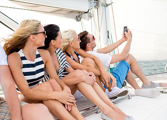 Image showing smiling friends sitting on yacht deck