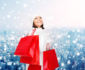Image showing smiling young woman with red shopping bags