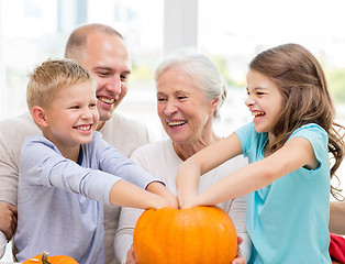 Image showing happy family sitting with pumpkins at home