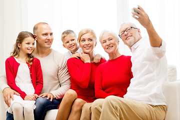 Image showing smiling family with camera at home