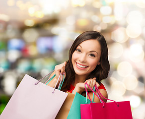 Image showing woman in red dress with shopping bags