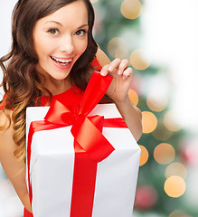 Image showing smiling woman in red dress with gift box