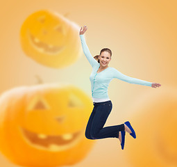 Image showing smiling young woman jumping in air