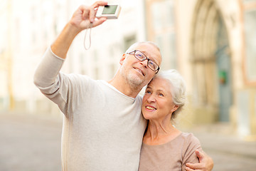 Image showing senior couple photographing on city street
