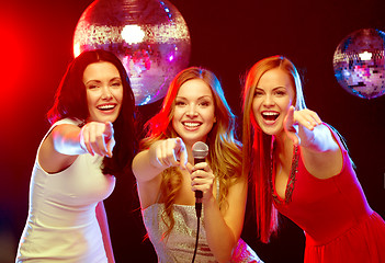 Image showing three smiling women dancing and singing karaoke