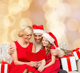 Image showing happy family in santa helper hats with gift boxes