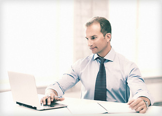 Image showing miling businessman working in office