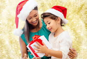 Image showing happy mother and girl in santa hats with gift box