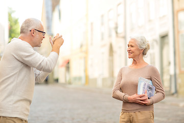 Image showing senior couple photographing on city street