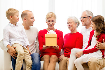 Image showing smiling family with gift at home