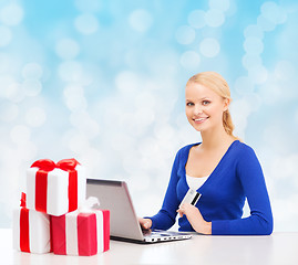 Image showing smiling woman with credit card and laptop