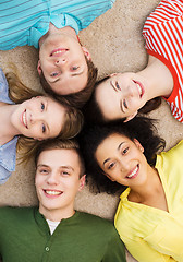 Image showing group of smiling people lying down on floor