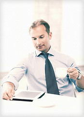 Image showing businessman with tablet pc and coffee in office