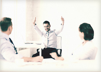 Image showing happy businessman showing thumbs up in office