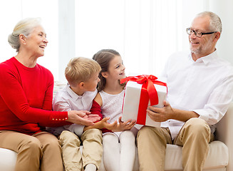 Image showing smiling family with gifts at home