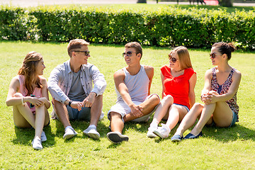 Image showing group of smiling friends outdoors sitting on grass