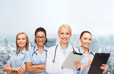 Image showing smiling female doctor and nurses with tablet pc