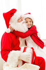 Image showing smiling girl with santa claus and gift at home