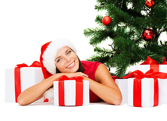 Image showing smiling woman in santa helper hat with gift boxes