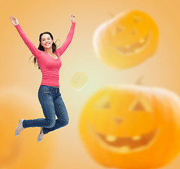 Image showing smiling young woman jumping in air