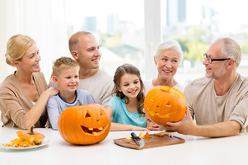 Image showing happy family sitting with pumpkins at home