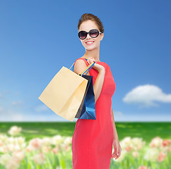Image showing smiling woman in red dress with shopping bags