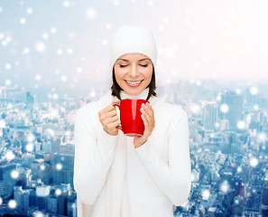 Image showing smiling young woman in winter clothes with cup