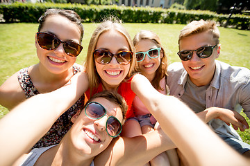 Image showing group of smiling friends making selfie in park