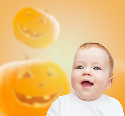 Image showing smiling baby over pumpkins background