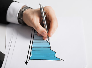 Image showing close up of male hand with pen drawing graph