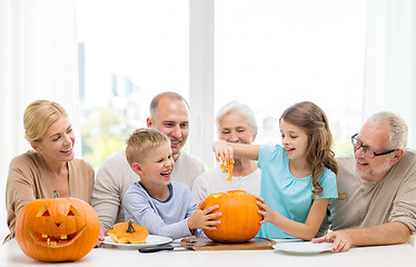 Image showing happy family sitting with pumpkins at home