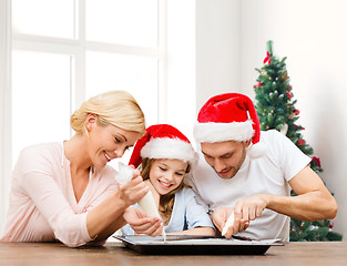 Image showing happy family in santa helper hats cooking